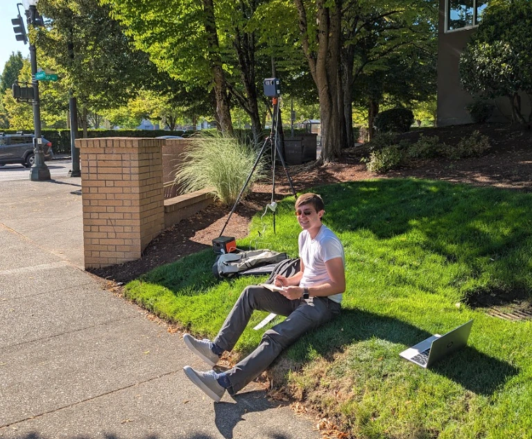 researcher counting roadway objects next to the traffic monitor mounted on a tripod