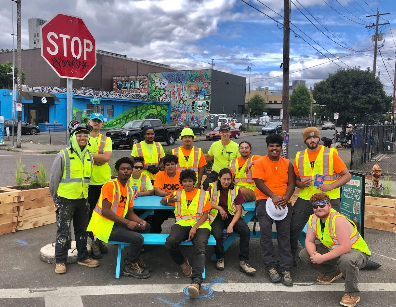 Depave volunteers in safety vests gathered at the plaza site